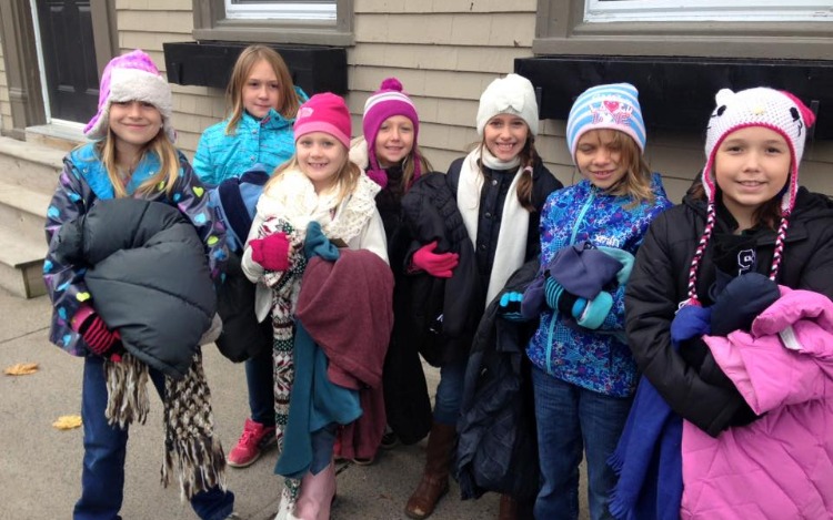 En el frío invierno boreal, Tara Smith Atkins junto a su hija y unas amigas, rescatan la esencia del espíritu navideño atando abrigos a los postes de calle, para que la gente sin hogar los pueda usar.